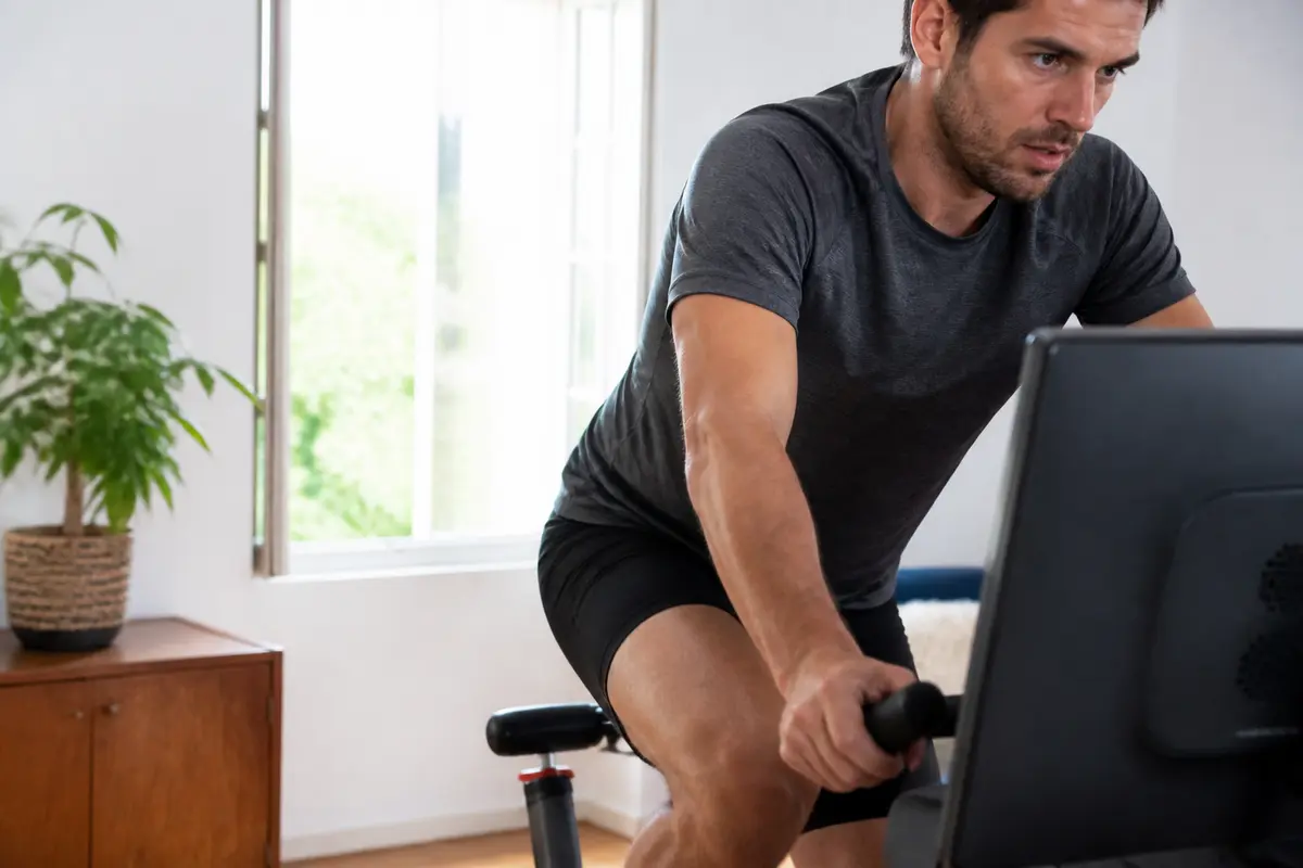 Homme concentré sur vélo d'appartement intérieur pour résultats avec 30 minutes quotidiennes